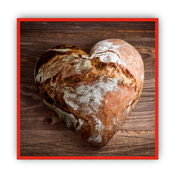Brot Aus der Vogelperspektive sieht man ein knuspriges Brot in Form von einem Herz.
